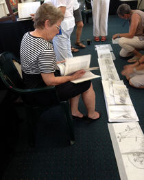 Panel 3 artist Billie Noli looks through a reference book.