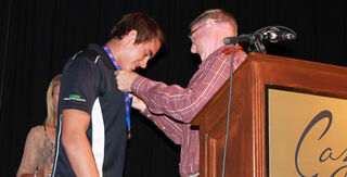 Michael McKeown receives the Reg Lillywhite medal from Reg Lillywhite.